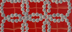A red painting with white pearl circles interconnected to each other forming 3 loop shapes vertically and 4 loop shapes horizontally.