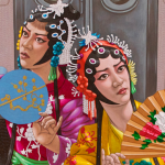 Two Asian opera performers dressed in colorful outfits appear in a 7 train subway car.
